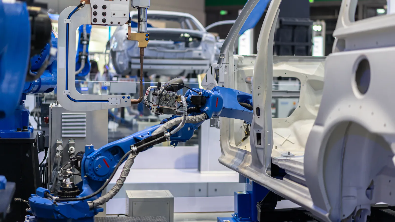 Robotic arms assembling vehicles on a factory line