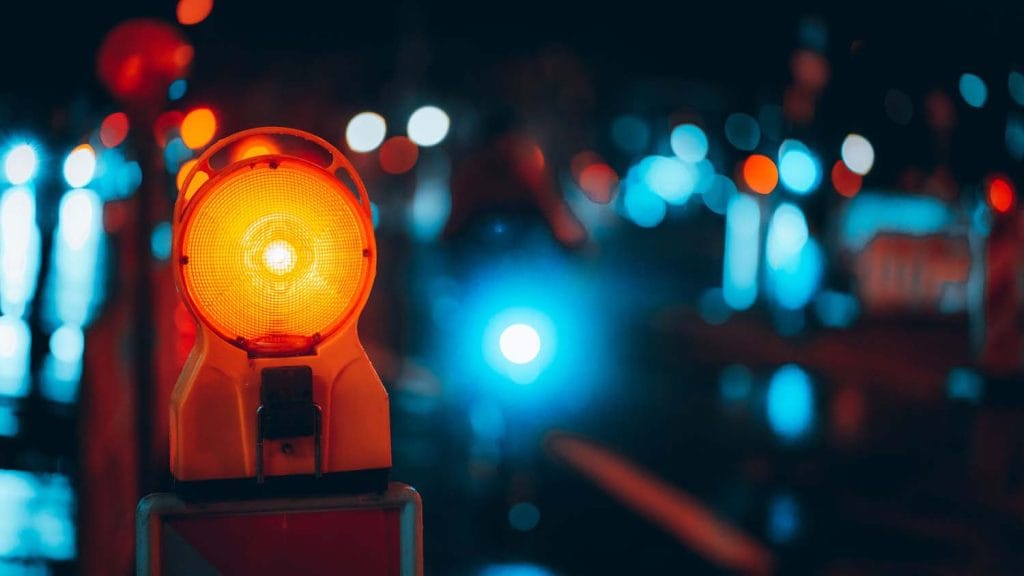 Closeup shot of a warning lamp in the street at night